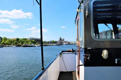 a boat is docked in the water on a river at Vita Nova in Amsterdam