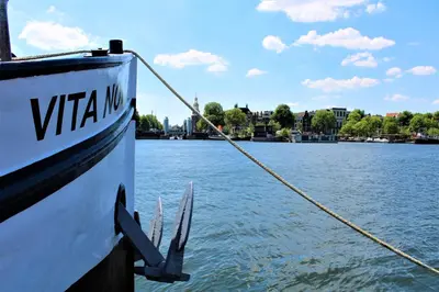 a boat is docked on the water with a rope at Vita Nova in Amsterdam