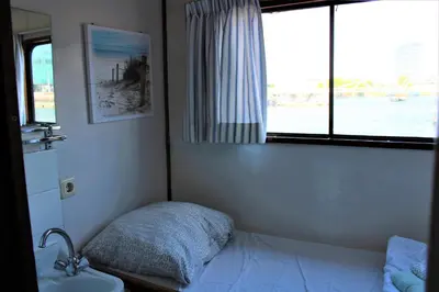 a bedroom with a bed and a sink and a window at Vita Nova in Amsterdam