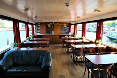 a restaurant with tables and chairs and a couch at Vita Nova in Amsterdam