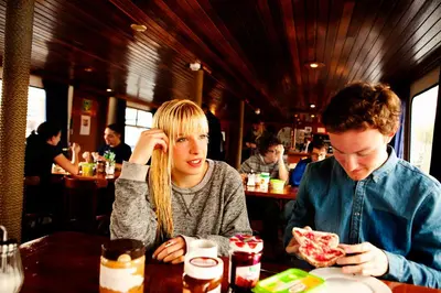 a man and a woman sitting at a table eating pizza at AmicitiA in Amsterdam