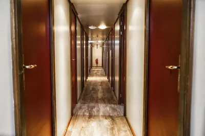 an empty corridor in a building with wood flooring at AmicitiA in Amsterdam