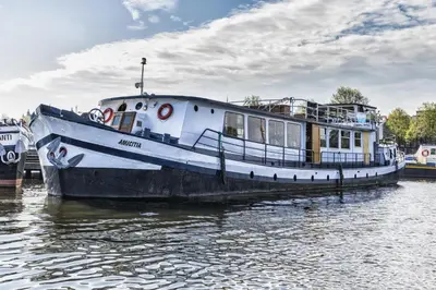 a white boat is docked in the water at AmicitiA in Amsterdam