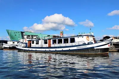 two boats are docked at a dock in the water at AmicitiA in Amsterdam