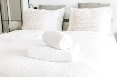 two white beds with towels on top of them at Studio at Sea in Zandvoort