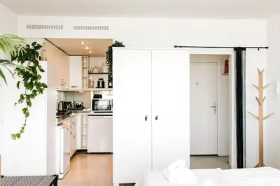 a white kitchen with white cabinets and appliances at Studio at Sea in Zandvoort