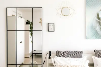 a living room with a glass cabinet and a mirror at Studio at Sea in Zandvoort