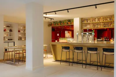 a bar in a restaurant with bar stools at Leonardo Eden Hotel Amsterdam City Center in Amsterdam