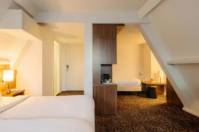 a hotel room with a bed and a bathroom at Leonardo Eden Hotel Amsterdam City Center in Amsterdam