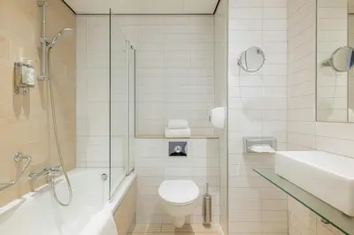 a bathroom with a toilet and a shower and a sink at Leonardo Eden Hotel Amsterdam City Center in Amsterdam