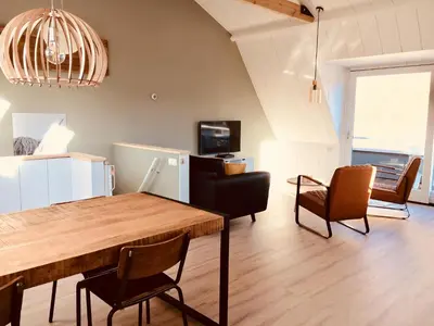 a living room with a dining room table and chairs at Vakantiehuis Witsand 1 in Egmond aan Zee
