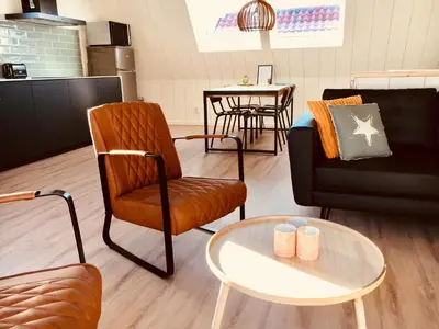 a living room with a chair and a table at Vakantiehuis Witsand 1 in Egmond aan Zee