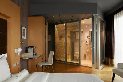 a bedroom with a bed and a bathroom with a shower at Amadi Park Hotel in Amsterdam
