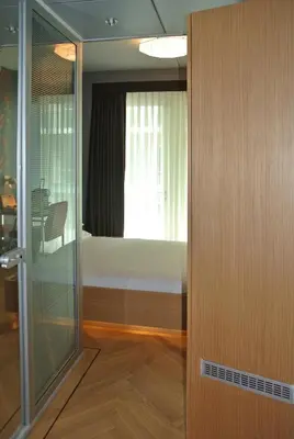 a sliding glass door leading to a bedroom with a bed at Amadi Park Hotel in Amsterdam