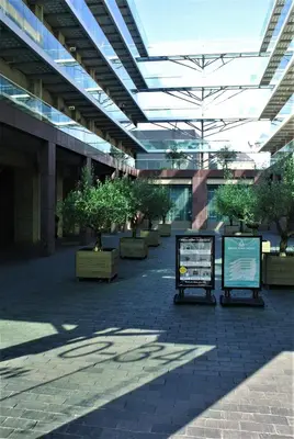 a large building with a courtyard with potted trees at Amadi Park Hotel in Amsterdam