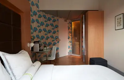 a bedroom with a white bed and a table at Amadi Park Hotel in Amsterdam
