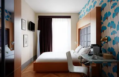 a bedroom with a bed and a desk with a computer at Amadi Park Hotel in Amsterdam