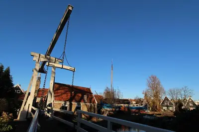 a crane sitting next to a marina with houses at De Krasse Man in Edam