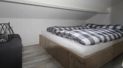 a bed with checkered pillows on top of it at Lodge in Noordwijk