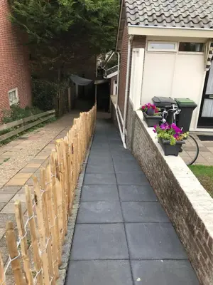 a sidewalk in front of a house with a fence at Lodge in Noordwijk