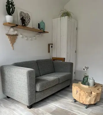 a living room with a gray couch and a wooden coffee table at Lodge in Noordwijk