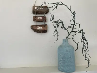 a blue vase sitting on a shelf next to a wall at Me Oissie in Egmond aan Zee