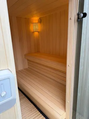 a small wooden sauna with a light in it at Sauna Cottage Egmond in Egmond aan Zee