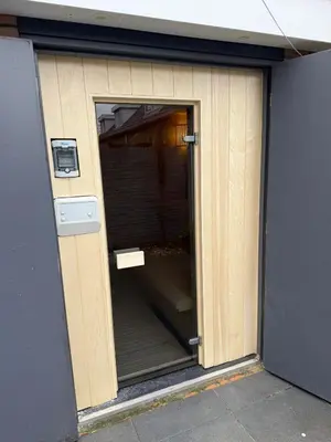 a door to a building with a sign on it at Sauna Cottage Egmond in Egmond aan Zee