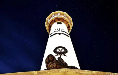 a white tower with a clock and an owl on it at Casa Nuestra in Egmond aan Zee