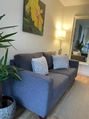 a blue couch in a living room with a plant at Artist House Amsterdam in Amsterdam