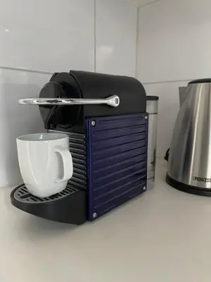 a coffee maker with a cup on a counter at Artist House Amsterdam in Amsterdam