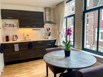 a kitchen with a table and a kitchen with a sink at Artist House Amsterdam in Amsterdam
