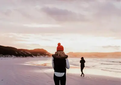 two people walking on the beach at sunset at Dutchen Vakantiepark Duynvoet in Schoorl