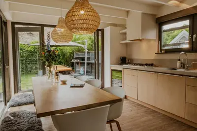 a kitchen with a large wooden table and chairs at Dutchen Vakantiepark Duynvoet in Schoorl