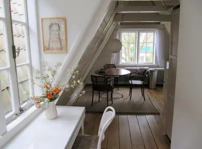 a living room with a table and chairs and a window at Kalkmarkt Suites in Amsterdam