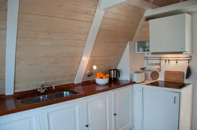 a kitchen with white cabinets and a sink at Kalkmarkt Suites in Amsterdam
