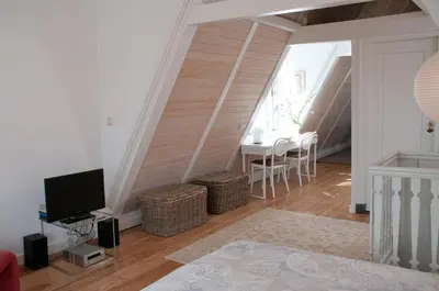 a living room with a tv and a table at Kalkmarkt Suites in Amsterdam