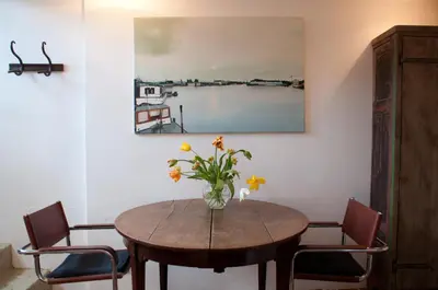 a dining room table with a vase of flowers on it at Kalkmarkt Suites in Amsterdam