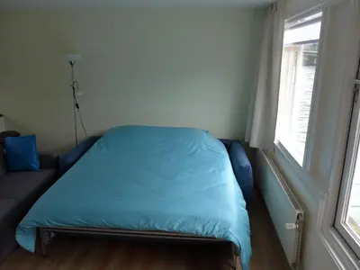 a small bed in a room with a window at Houseboat In The Center, 5 min walk to Tropical Museum, Free Wifi! in Amsterdam
