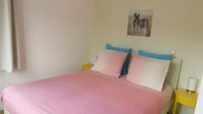 a bedroom with a pink bed with four pillows at Houseboat In The Center, 5 min walk to Tropical Museum, Free Wifi! in Amsterdam
