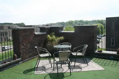 a patio with a table and chairs on a balcony at B&B Het kasteel in Almere