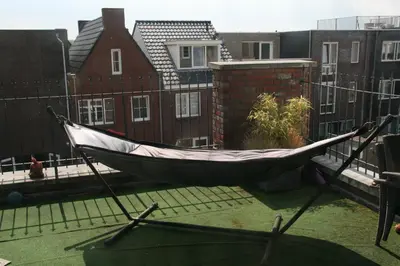 a hammock on a balcony in a house at B&B Het kasteel in Almere