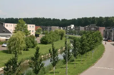 a street in a city with a river at B&B Het kasteel in Almere
