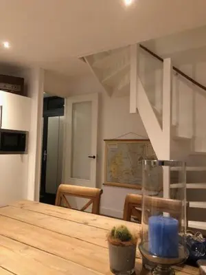 a room with a wooden table with a vase on it at Appartement 4 Seasons Katwijk aan Zee in Katwijk aan Zee
