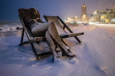 a woman sitting in a chair covered in snow at Appartement 4 Seasons Katwijk aan Zee in Katwijk aan Zee