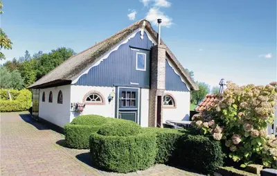 a small white building with a thatched roof at Hoeve Alegria in Hoogwoud