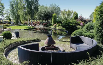 a garden with a table and a lamp and a pond at Hoeve Alegria in Hoogwoud