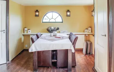 a dining room with a table with chairs and a window at Hoeve Alegria in Hoogwoud