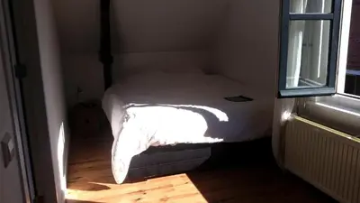 a small bed in a small room with a window at Zoetermeer City Center Loft Apartment in Zoetermeer