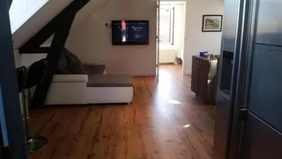 a living room with a couch and a tv on the wall at Zoetermeer City Center Loft Apartment in Zoetermeer